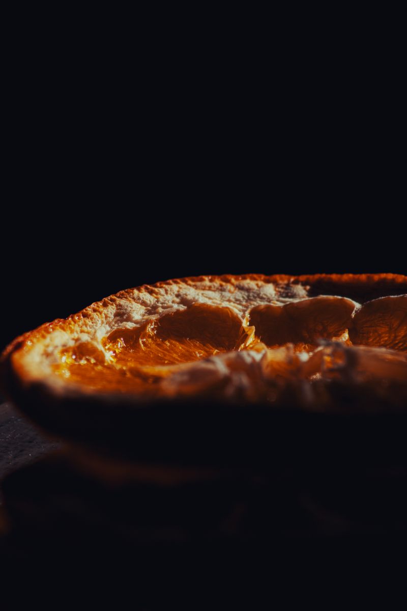Macro photograph of a sliced bergamot glowing against a dark background